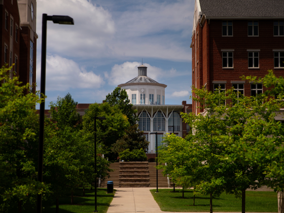 A distant view of the W.T. Young library framed by other buildings and green trees.